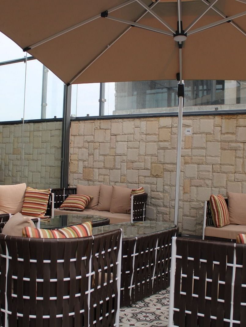 Back view of a rooftop lounge featuring stylish seating arrangements and a spacious patio area at BluSalzz Residence, Amritsar 